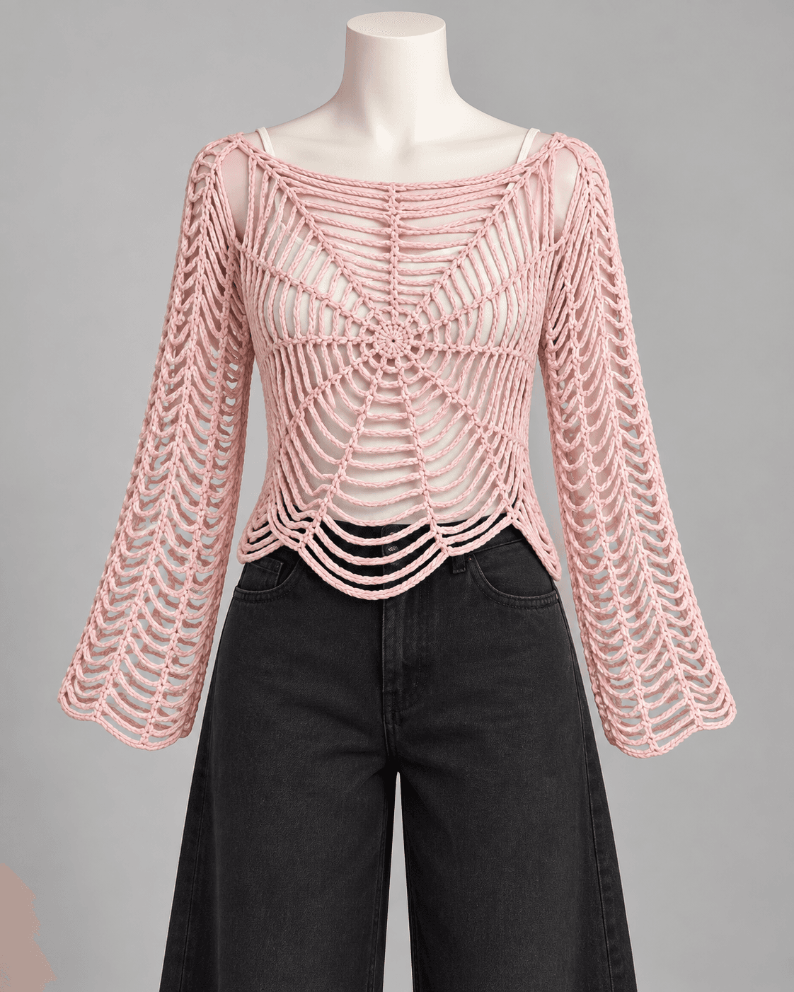 Blush pink spiderweb crochet top with bell sleeves worn over a white cami